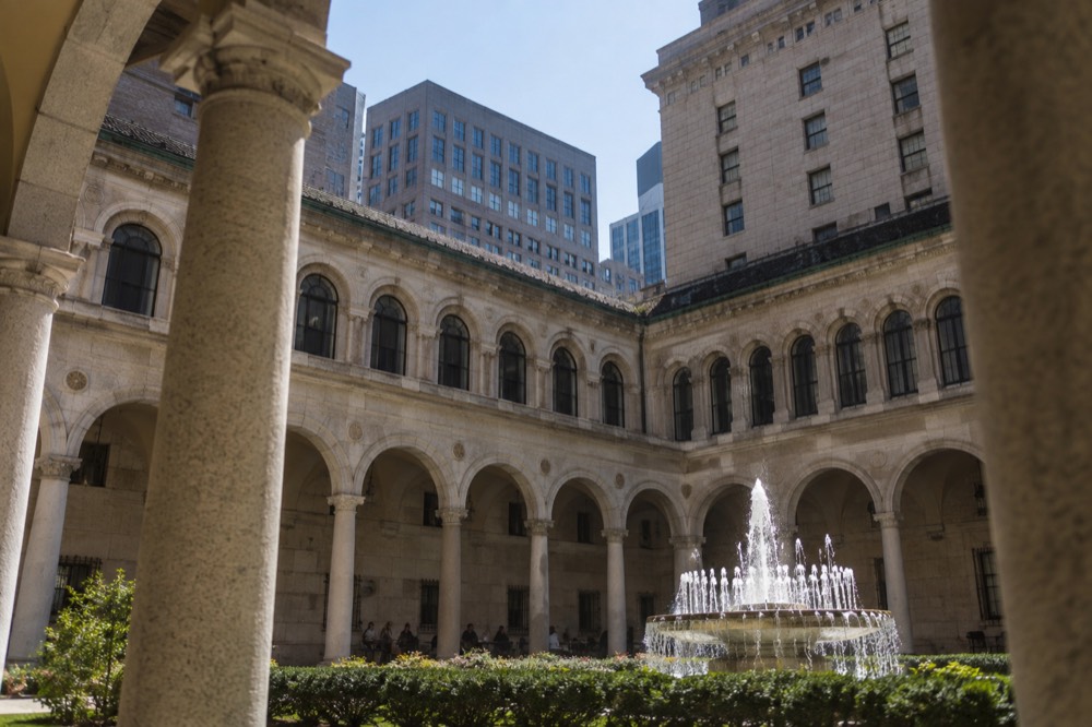 Sunlight falling on the arcaded courtyard and fountain of the Boston Public Library
