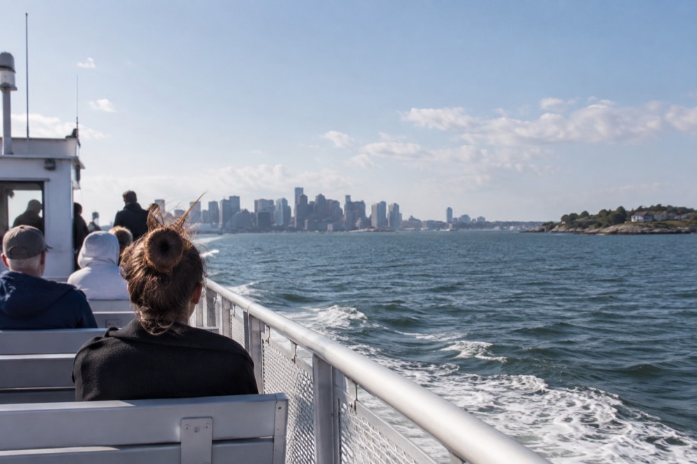A ferry crossing open water toward a New England island harbor