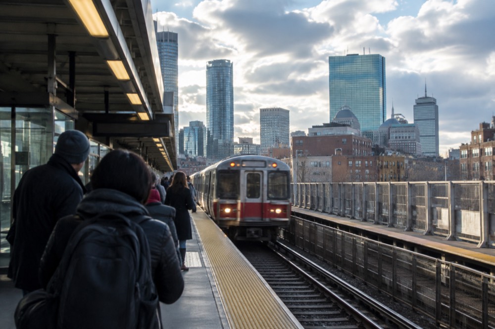 Boston subway platform with a train arriving and passengers waiting
