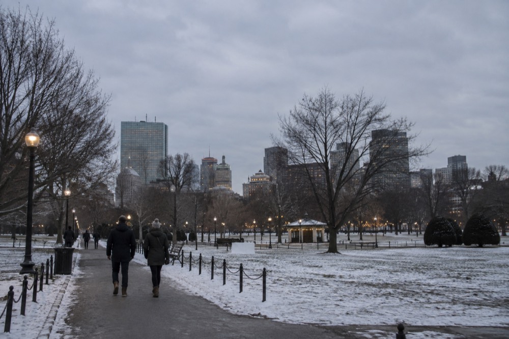 Festive lights strung above a snow-dusted Boston street in December