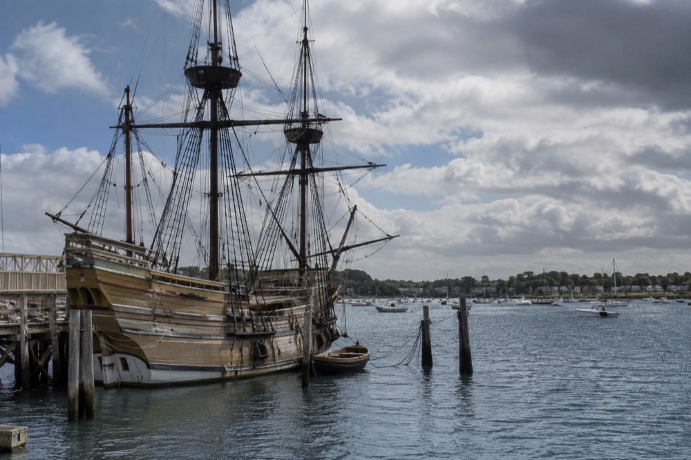 A historic sailing ship anchored near a New England waterfront town