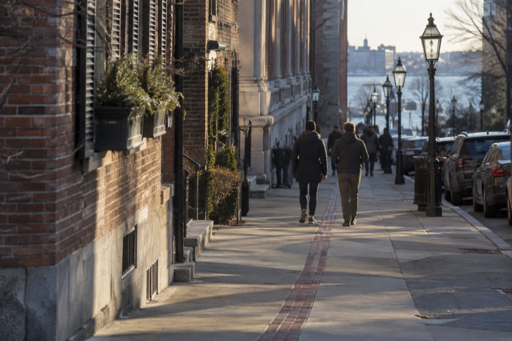The red brick Freedom Trail line running along a Boston sidewalk past historic buildings