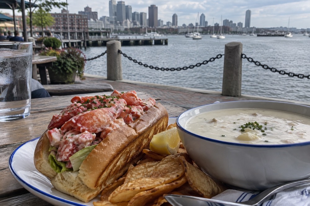 Lobster rolls and clam chowder served together on a waterfront restaurant table