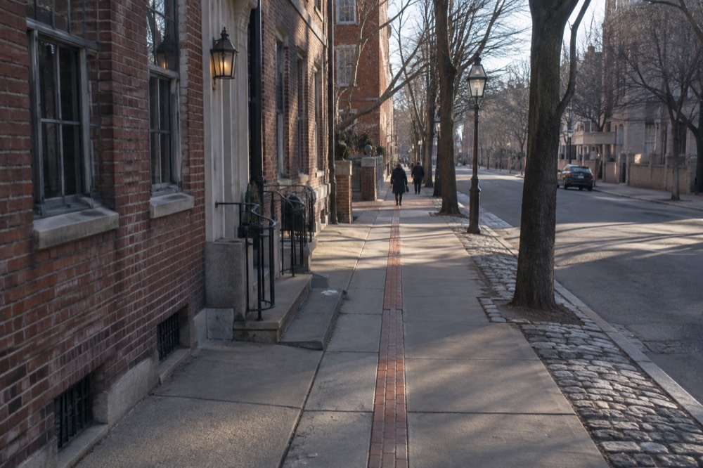 The red brick Freedom Trail line running along a Boston sidewalk past historic buildings