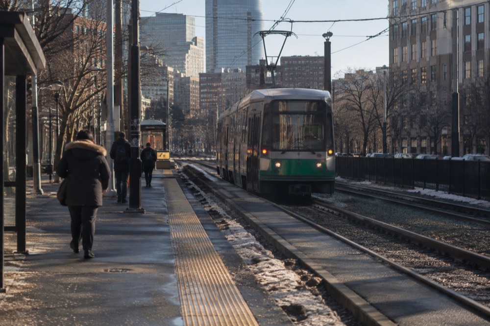 An MBTA Green Line trolley arriving at a surface station in Boston