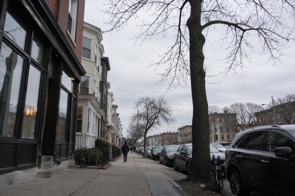 Row houses and storefronts along a busy commercial avenue in Allston