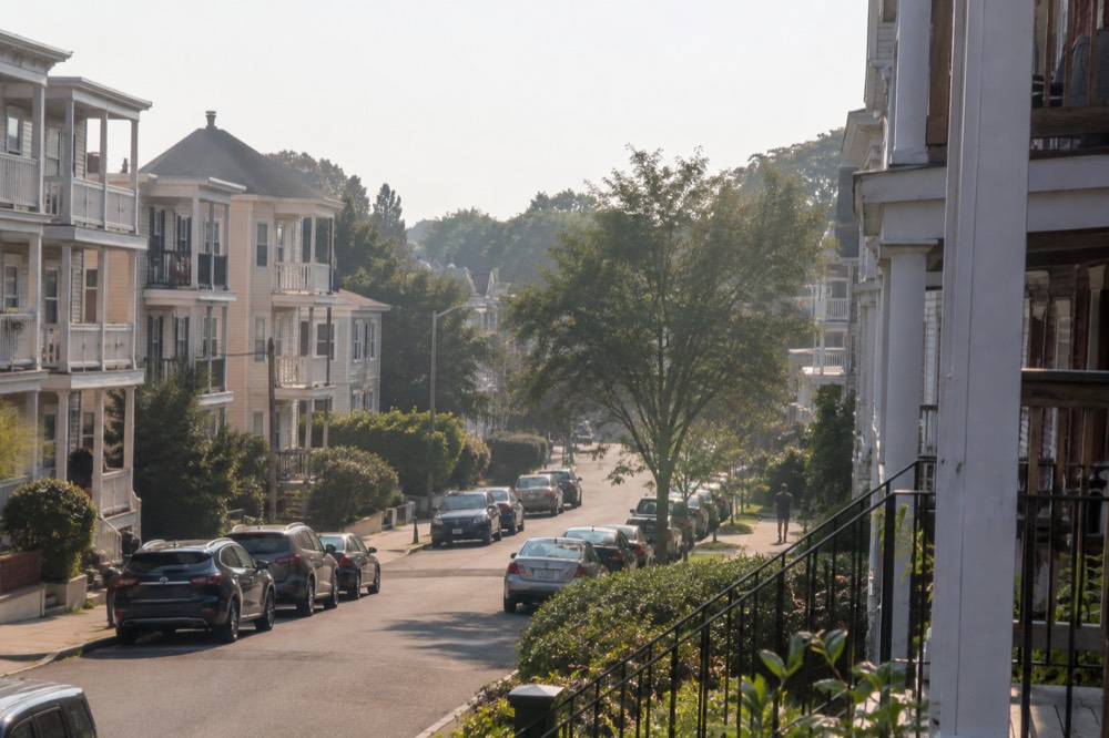A quiet residential street of triple-decker houses in Brighton