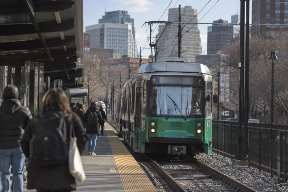 Green Line trolley arriving at an MBTA station platform in Boston