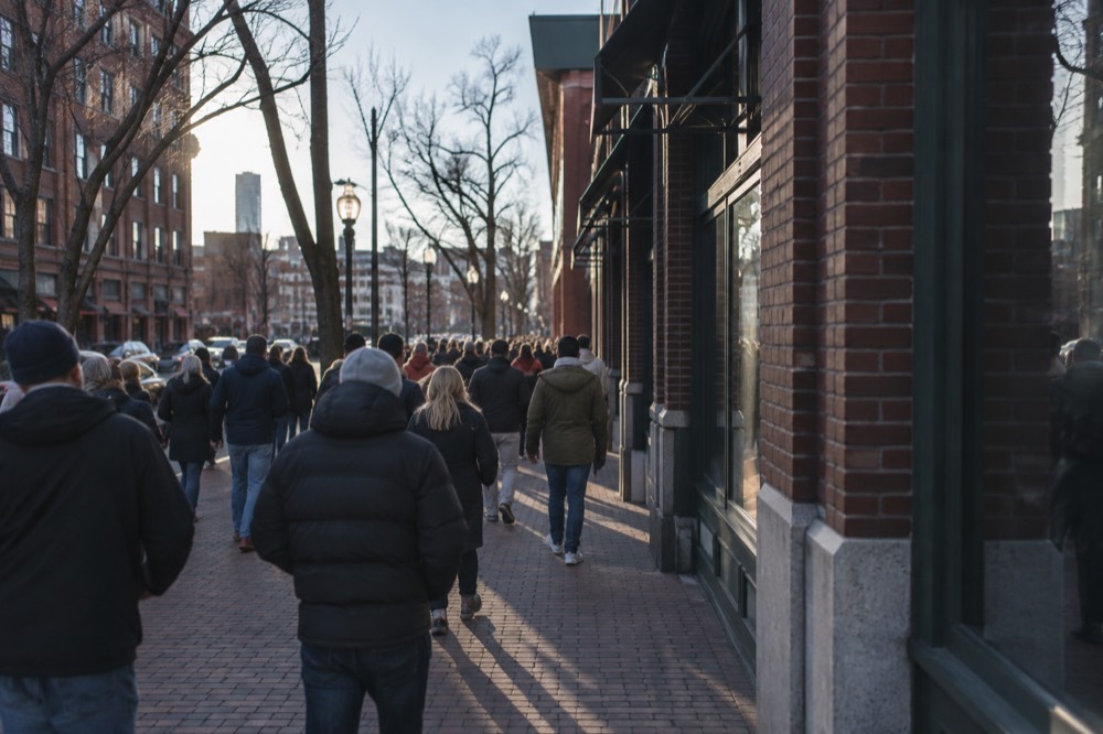 Baseball fans crowd a brick sidewalk outside the ballpark on a game day