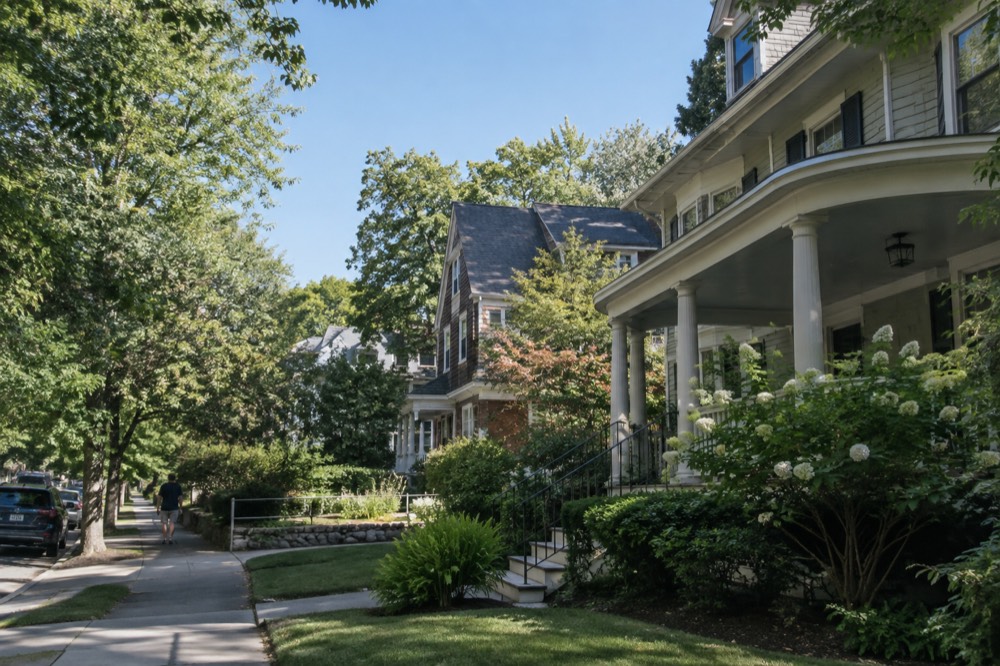 A historic porch-front house on a quiet residential street with mature shade trees