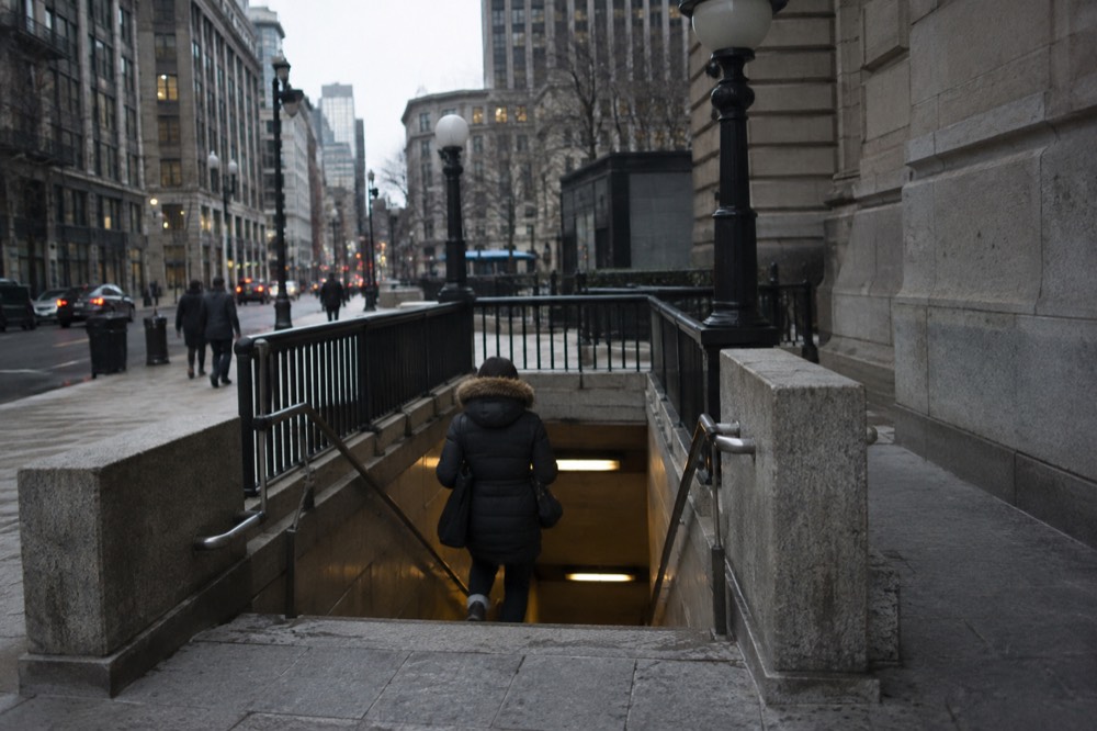 An MBTA subway entrance with a station sign on a downtown Boston sidewalk