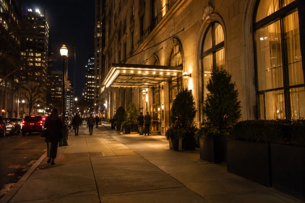 A downtown Boston street at night with lit hotel and theater signs