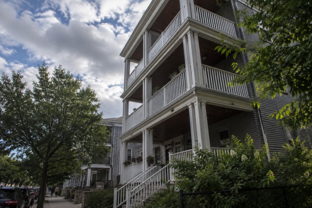 A triple-decker house with three floors of porches on a Dorchester side street