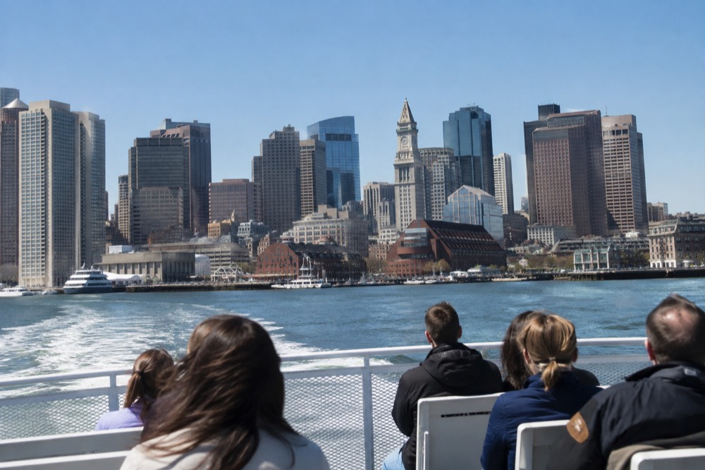 A ferry crossing the harbor toward downtown Boston with the Custom House tower visible