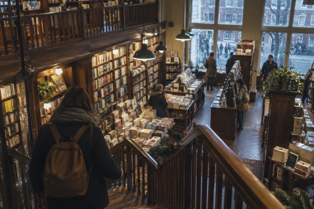 A multi-level bookstore interior with wooden shelves and browsers