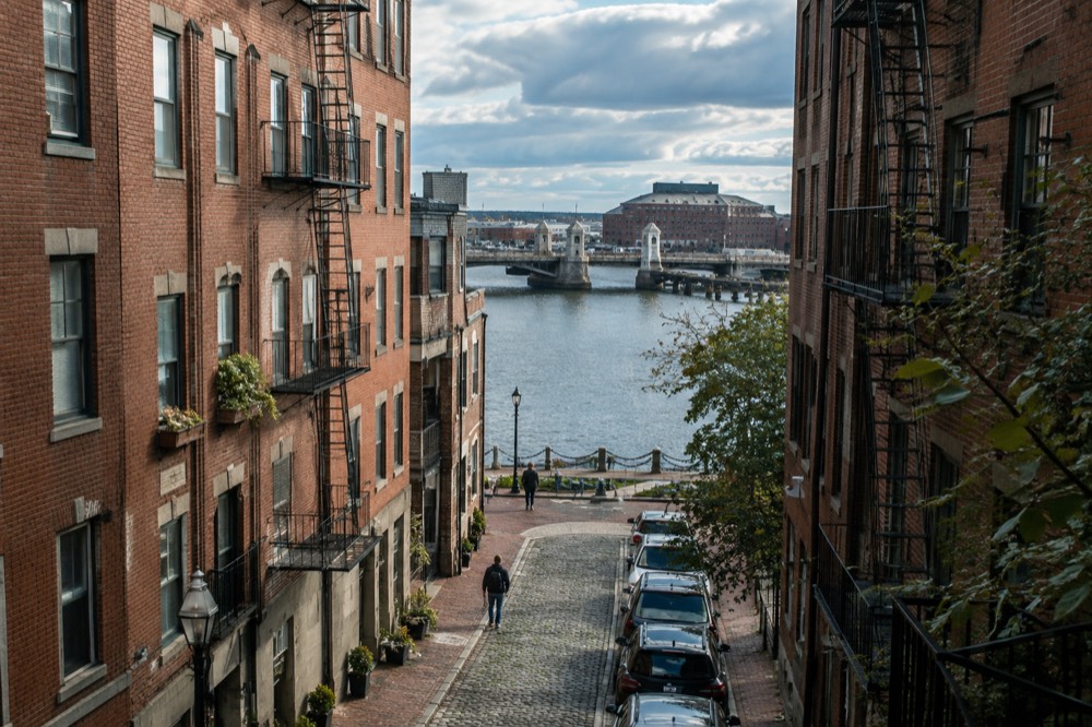 Historic stone bridge crossing harbor water toward old navy yard buildings