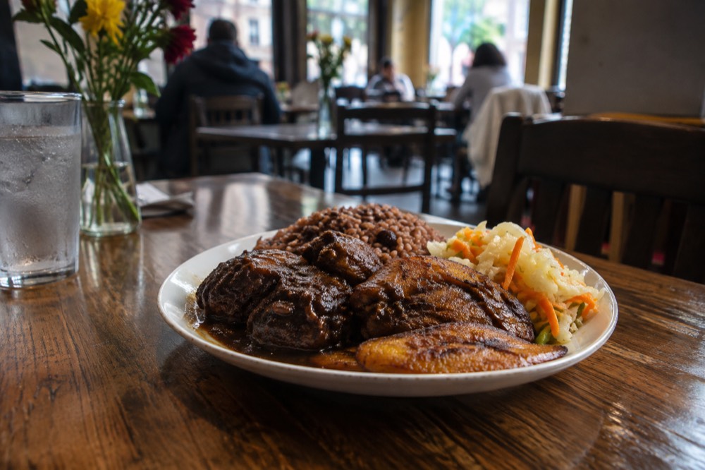 A plate of Caribbean food on a restaurant table