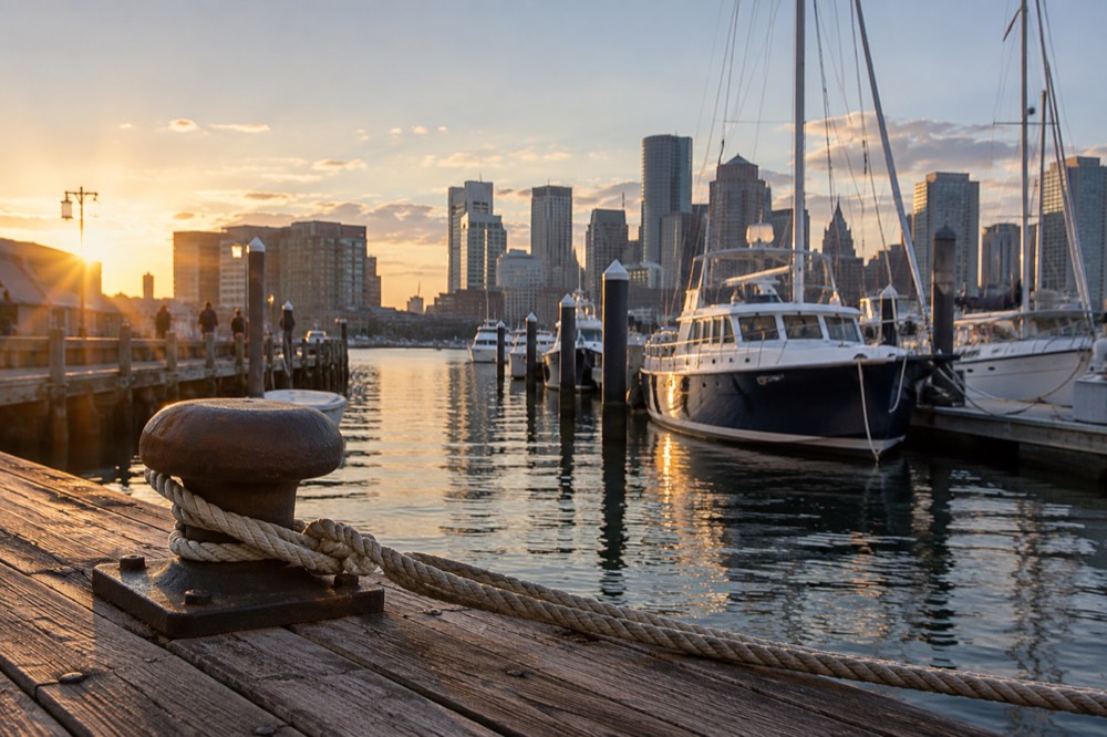 Long Wharf in Boston with moored boats and the harbor skyline behind them