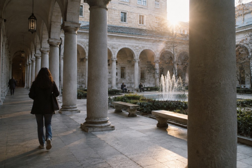 Renaissance revival courtyard with an arcade of arches around a fountain and stone benches