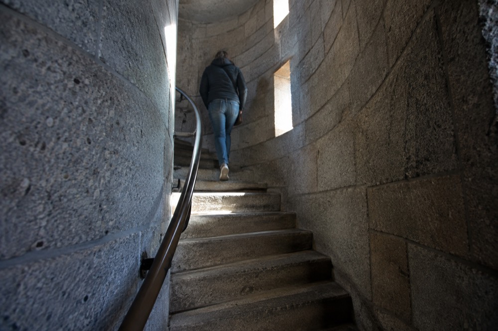 A spiral stone staircase inside a narrow monument shaft