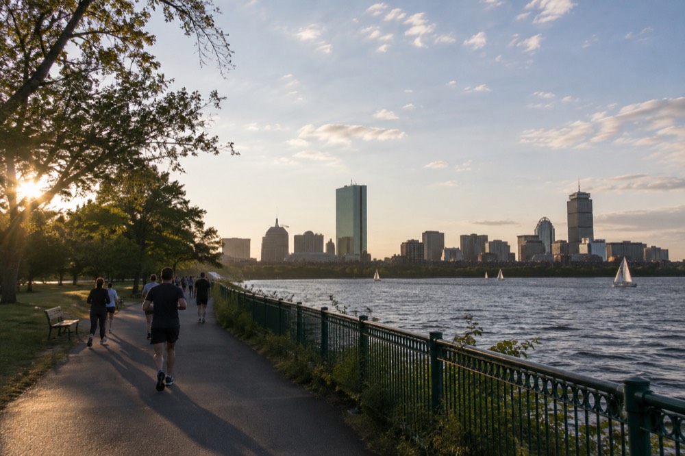 People walking and jogging along the Esplanade path with the Boston skyline behind them