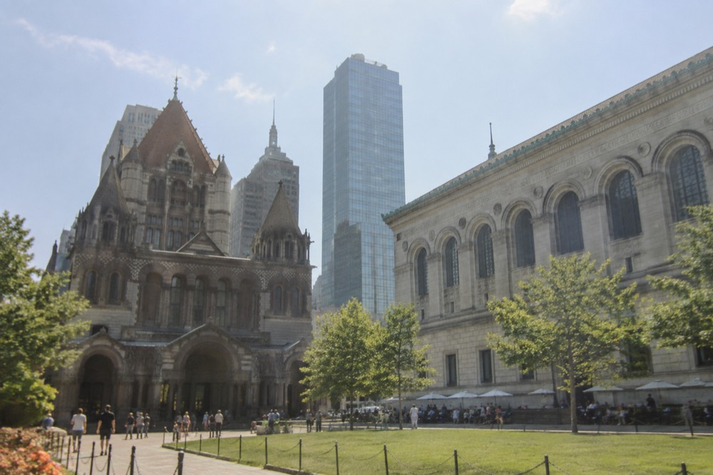 Trinity Church rising above Copley Square with the Boston Public Library across the plaza