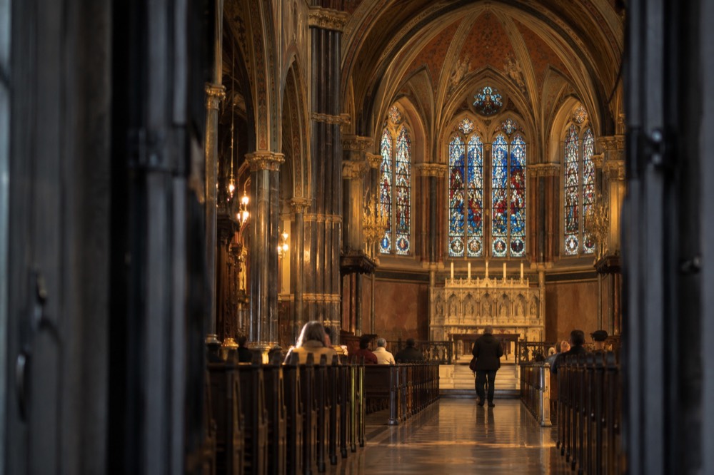 The painted interior arches and stained glass of Trinity Church's nave seen from the entrance