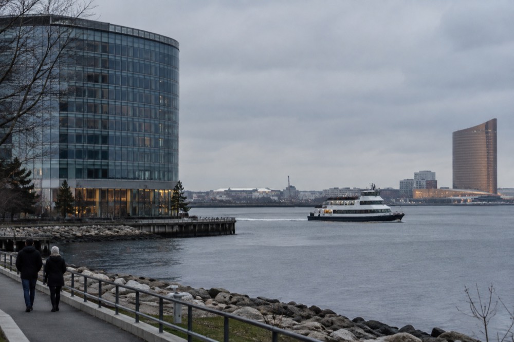 A ferry crossing Boston Harbor with the Encore Boston Harbor tower visible across the water