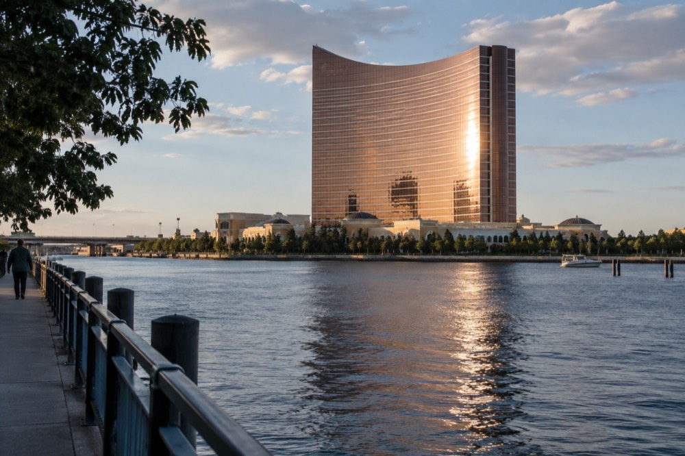 The Encore Boston Harbor tower glowing with evening light above the Mystic River