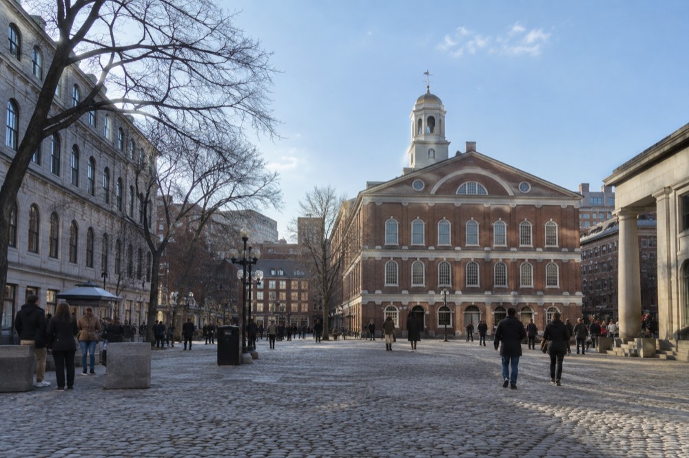 The historic Faneuil Hall brick building with its grasshopper weathervane, seen from the market square in downtown Boston