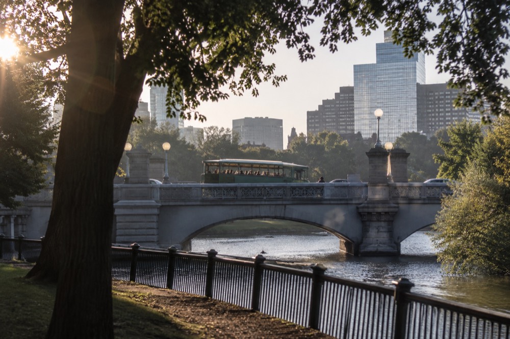 An amphibious duck boat vehicle crossing a Boston bridge on a city tour