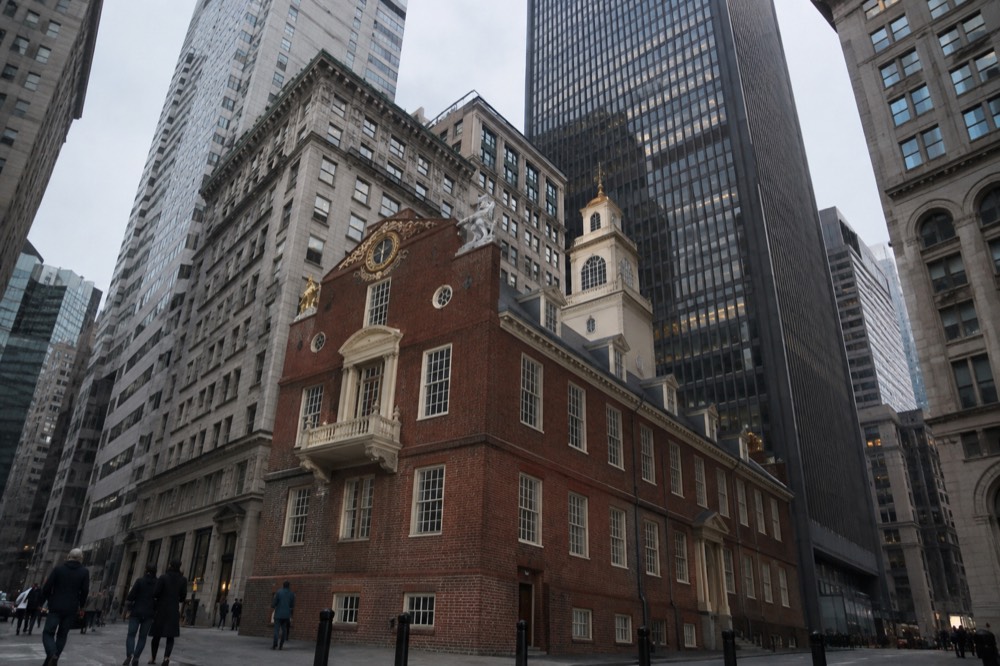 The red brick Old State House standing among modern glass office towers in downtown Boston
