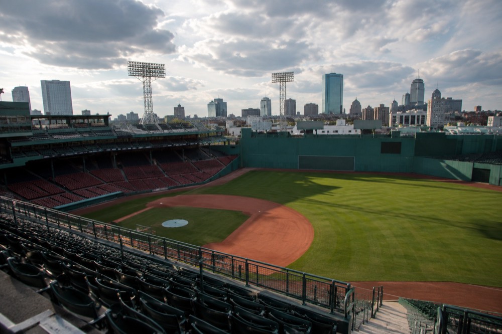 An empty seating bowl inside a historic ballpark seen from the upper deck