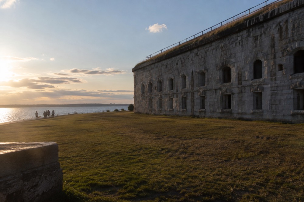 Granite walls of Fort Warren on Georges Island rising above a grassy parade ground in Boston Harbor
