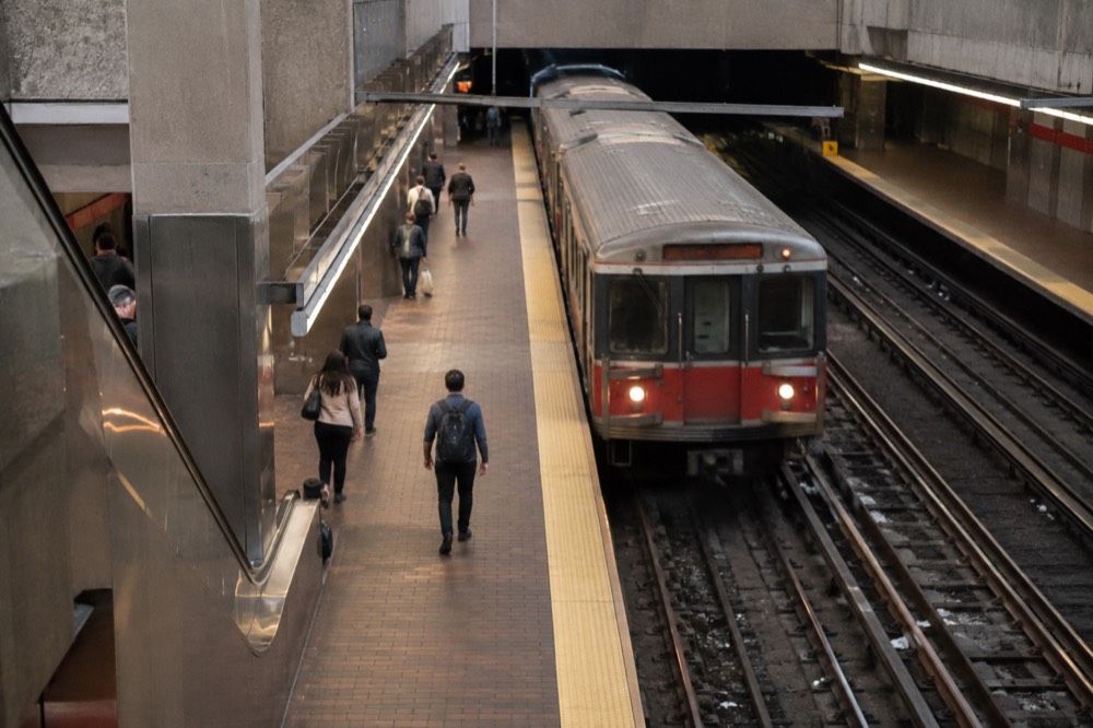 A subway platform with a red line train arriving