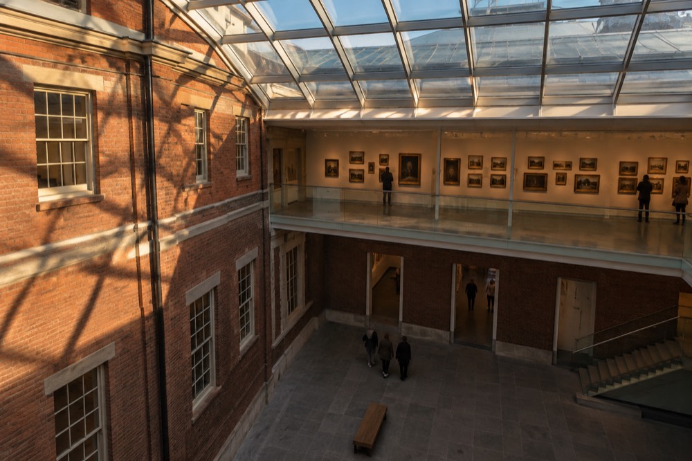 Paintings hung salon style on a gallery wall