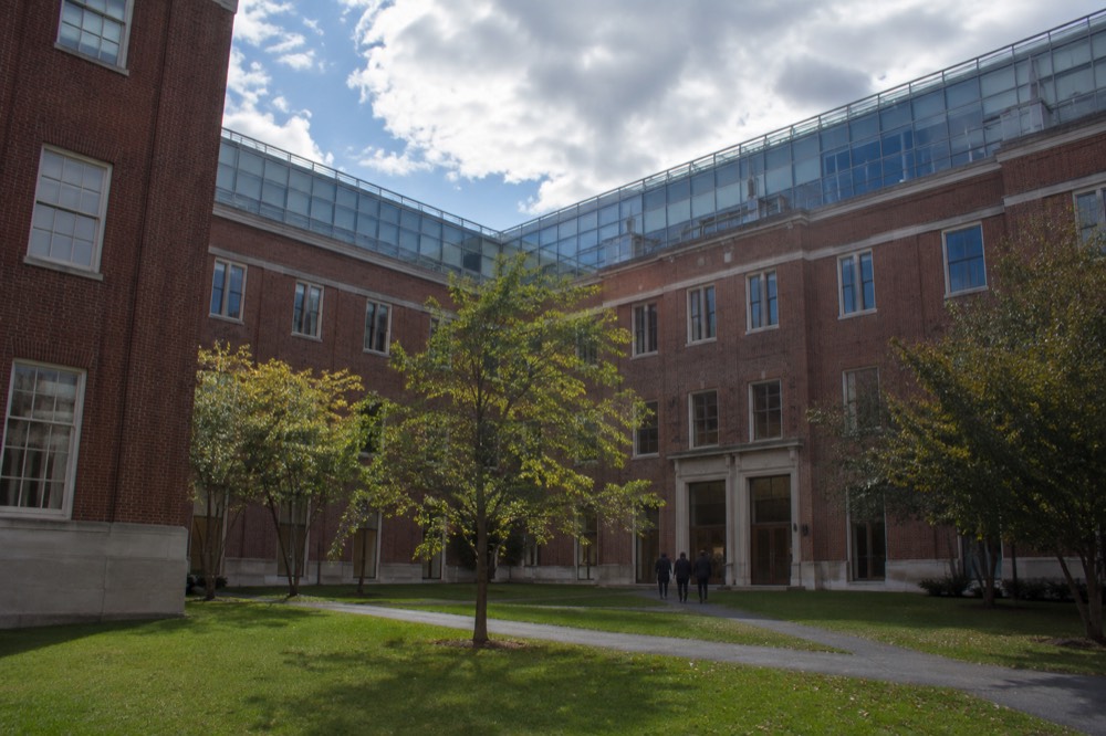 A red brick university building with green lawn in front