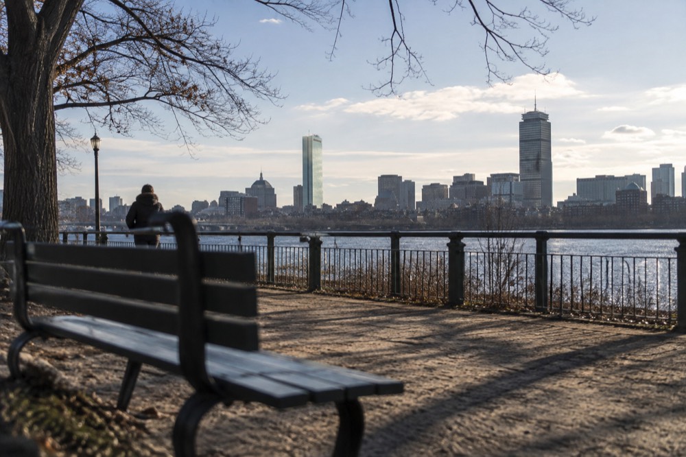 A view across a river toward a city skyline with a historic university tower prominent