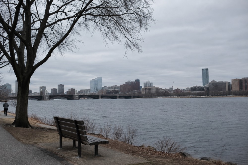 View across the Charles River of Cambridge buildings with a bridge connecting to Boston