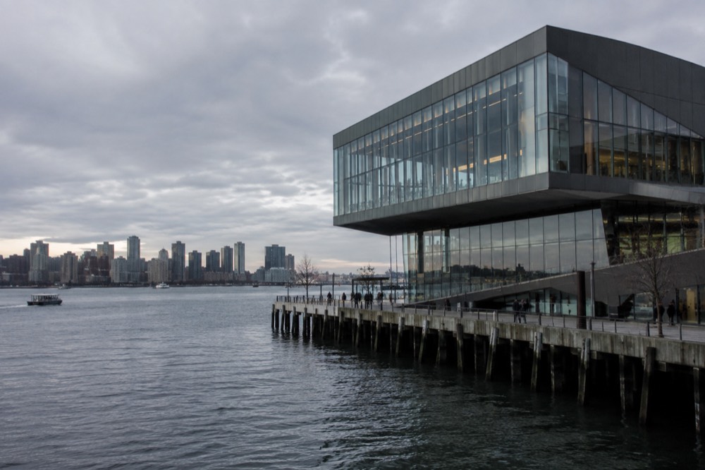 A modern glass museum building on Boston's waterfront with harbor water in the foreground