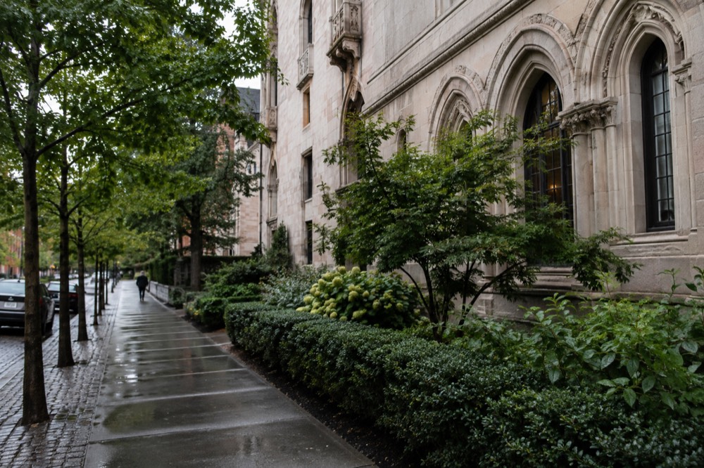 A stone palace facade with arched windows beside a quiet Boston street