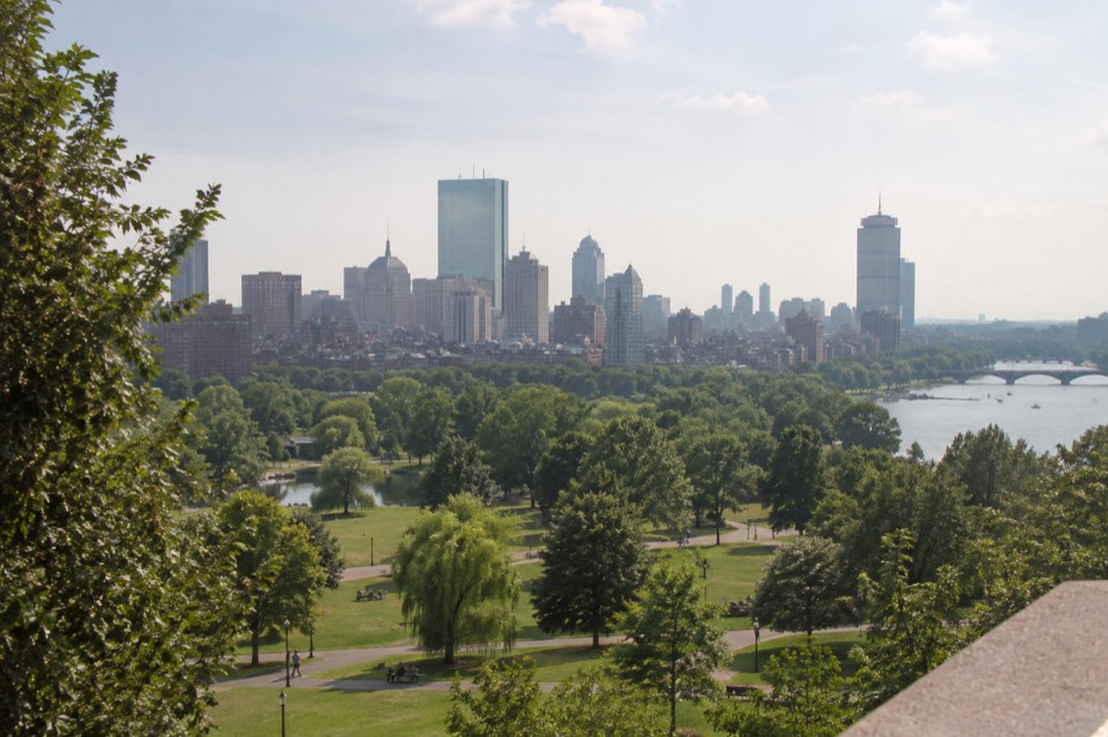 A city skyline view from an observation deck with buildings and a river in the distance