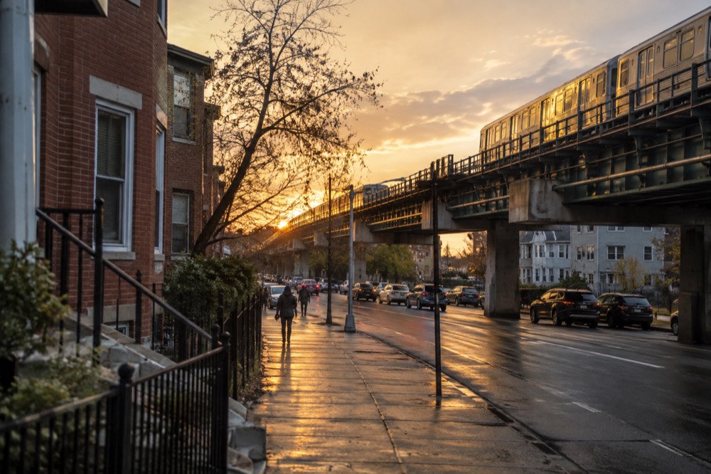 Elevated subway tracks crossing a Dorchester neighborhood at golden hour