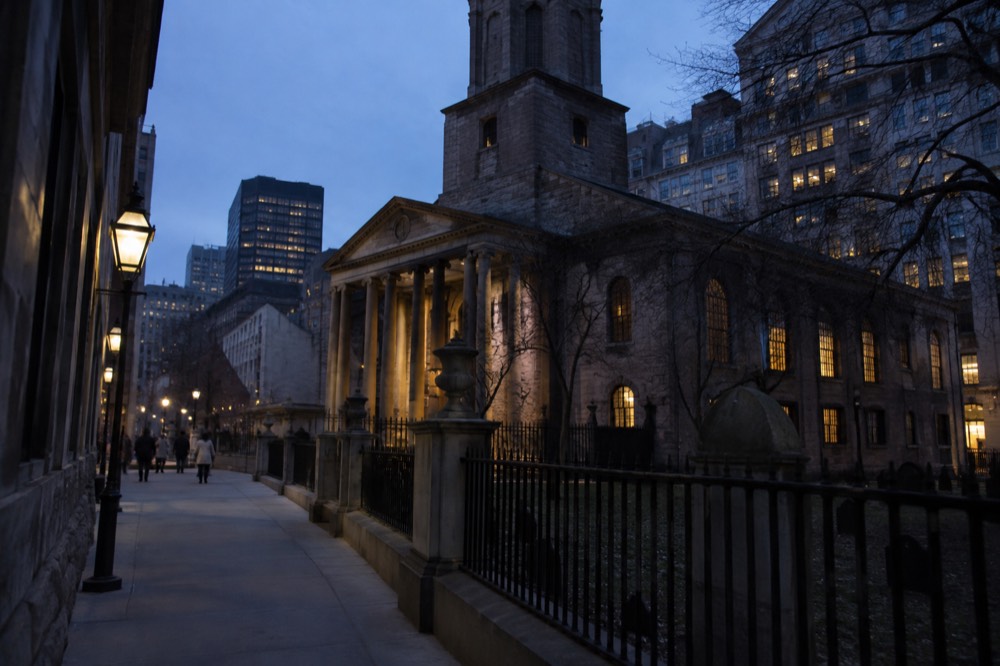 Colonial gravestones leaning at angles in a small fenced burying ground