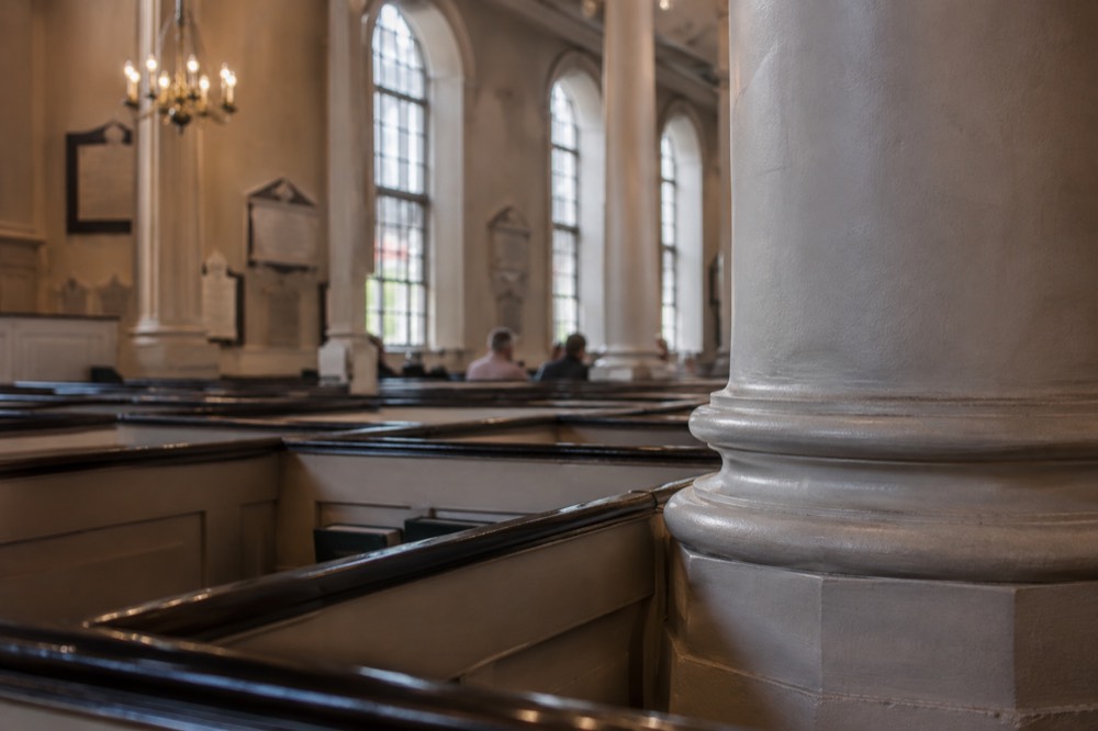 Interior of a Georgian church with box pews and a stone column