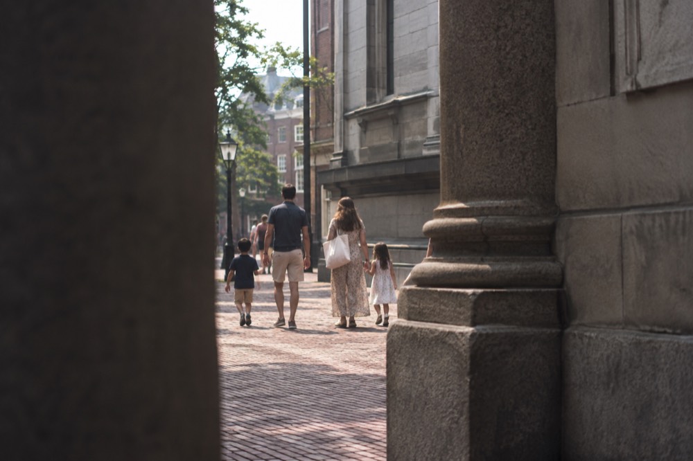 Family with children walking along a colonial-era brick street