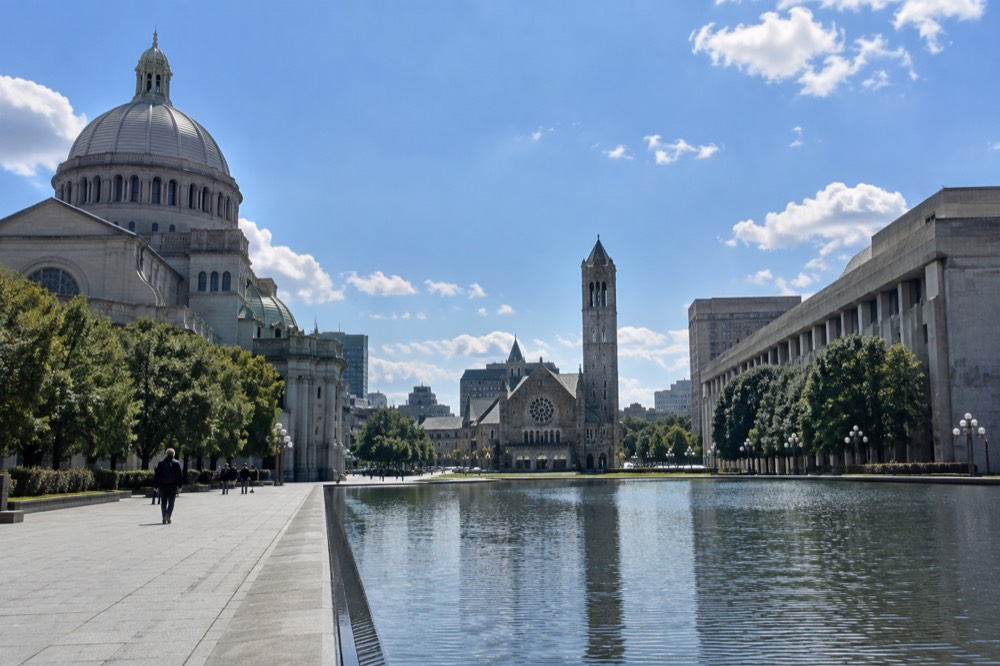 A wide boulevard with a reflecting pool and large church buildings in Boston
