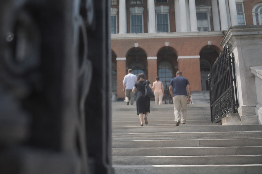 Visitors walking up the stone steps toward the State House entrance