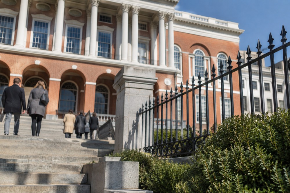 The red brick and white columns of the State House facade in sunlight