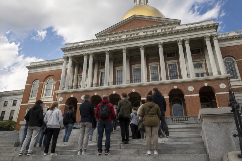 A tour group gathered on the State House steps listening to a guide